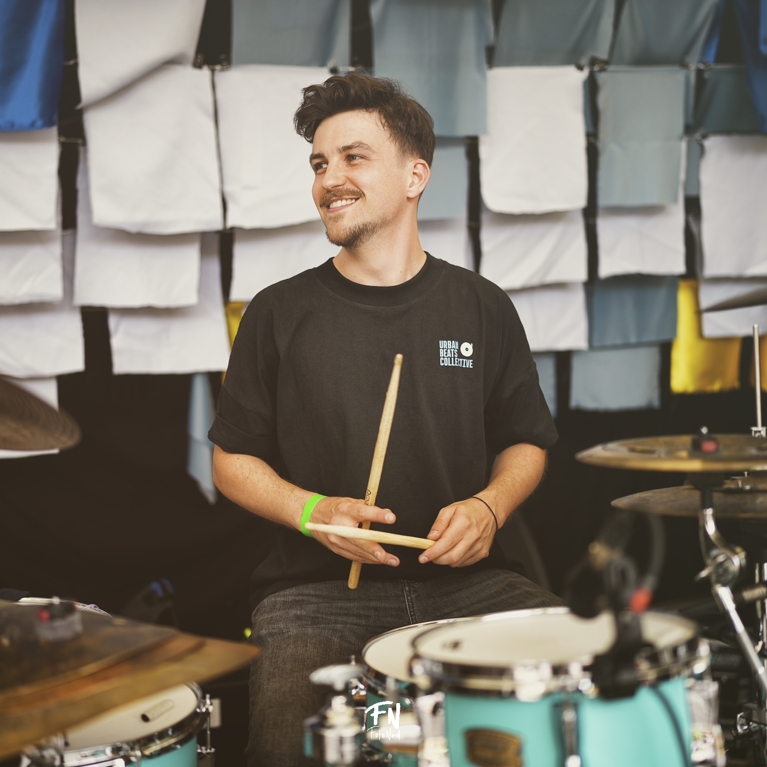 Julian Feuchter smiling behind his turquoise drum kit