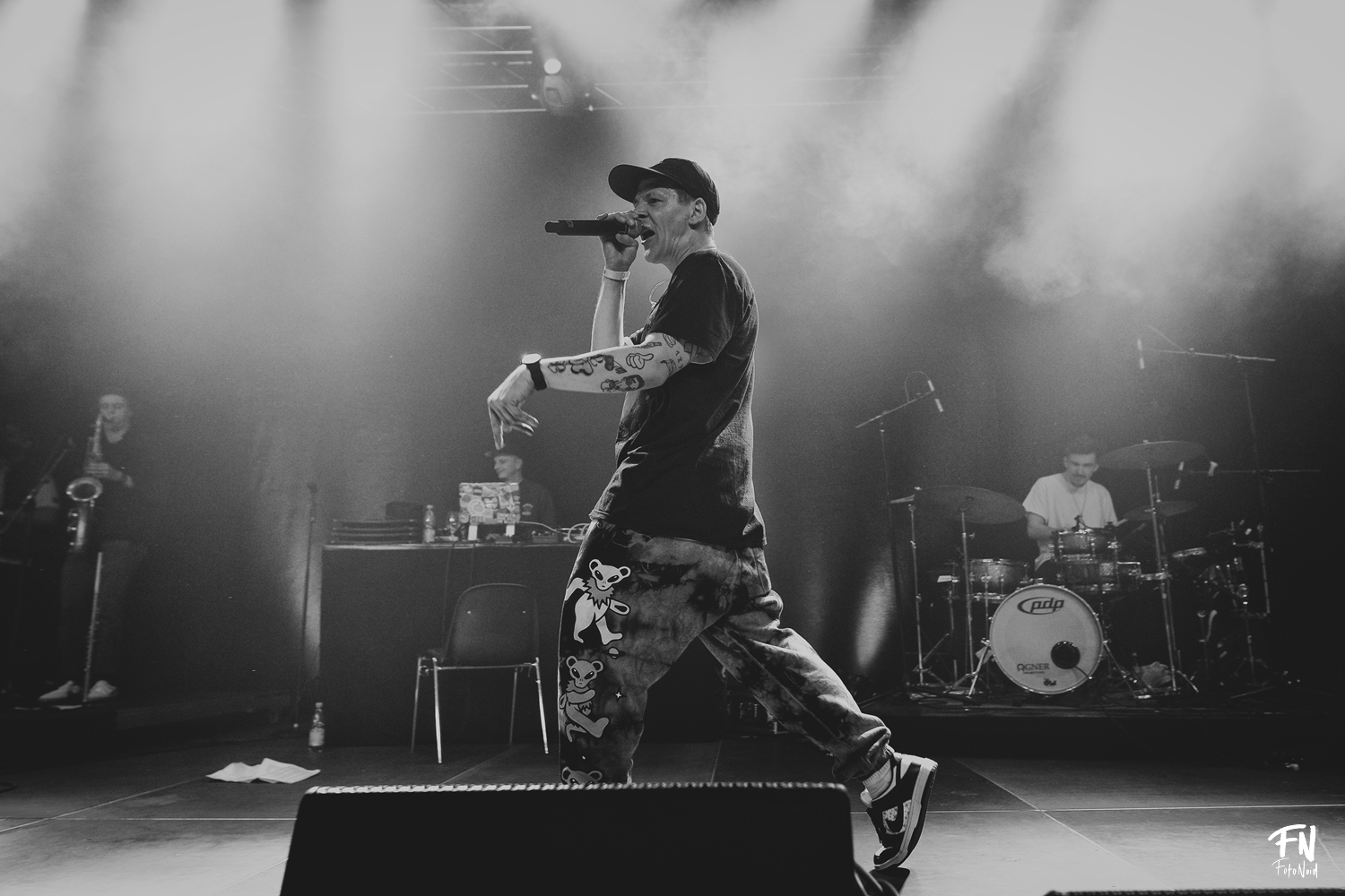 Black-and-white shot of a rapper on stage with Julian Feuchter at the drums behind