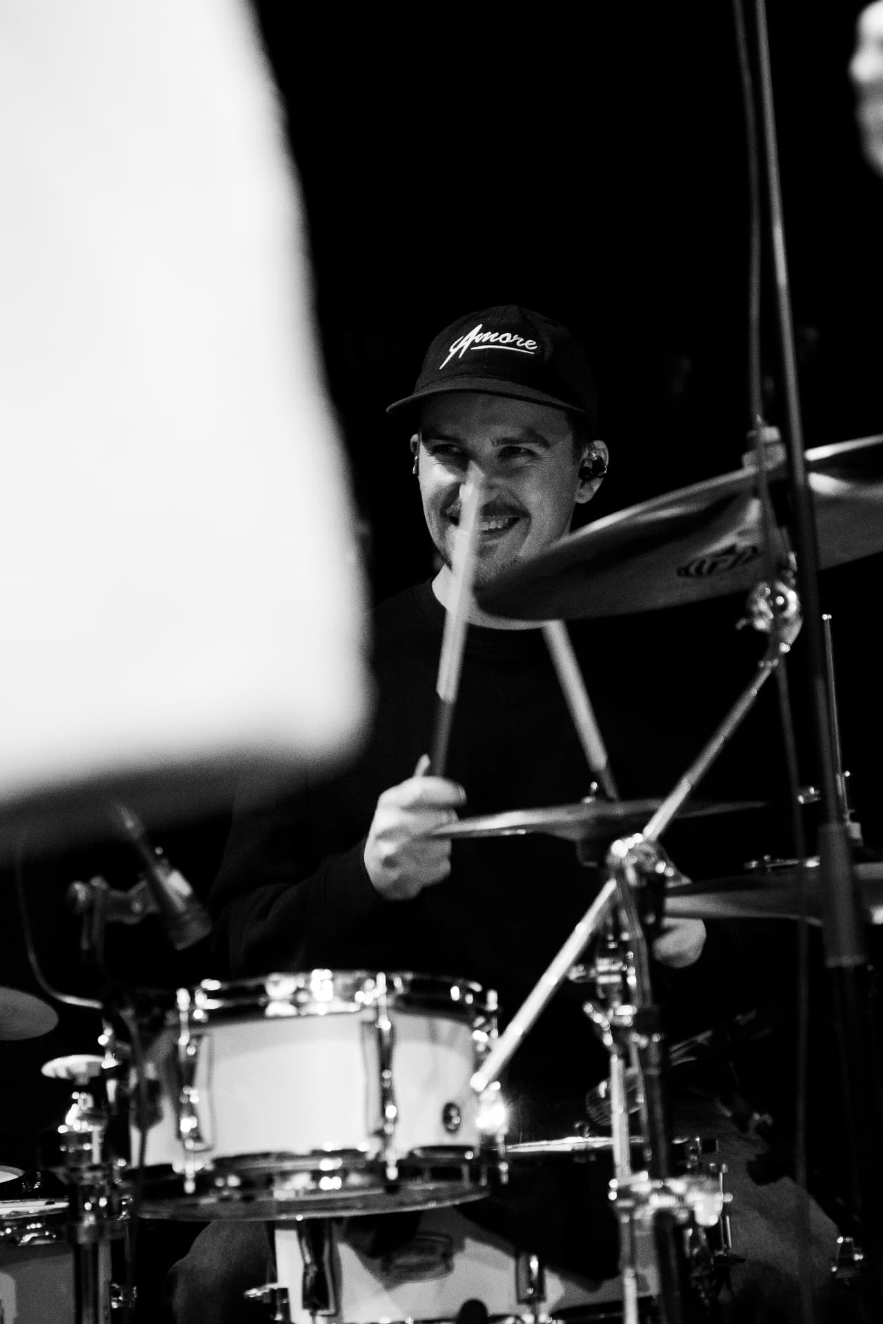 Julian Feuchter smiling while playing drums live
