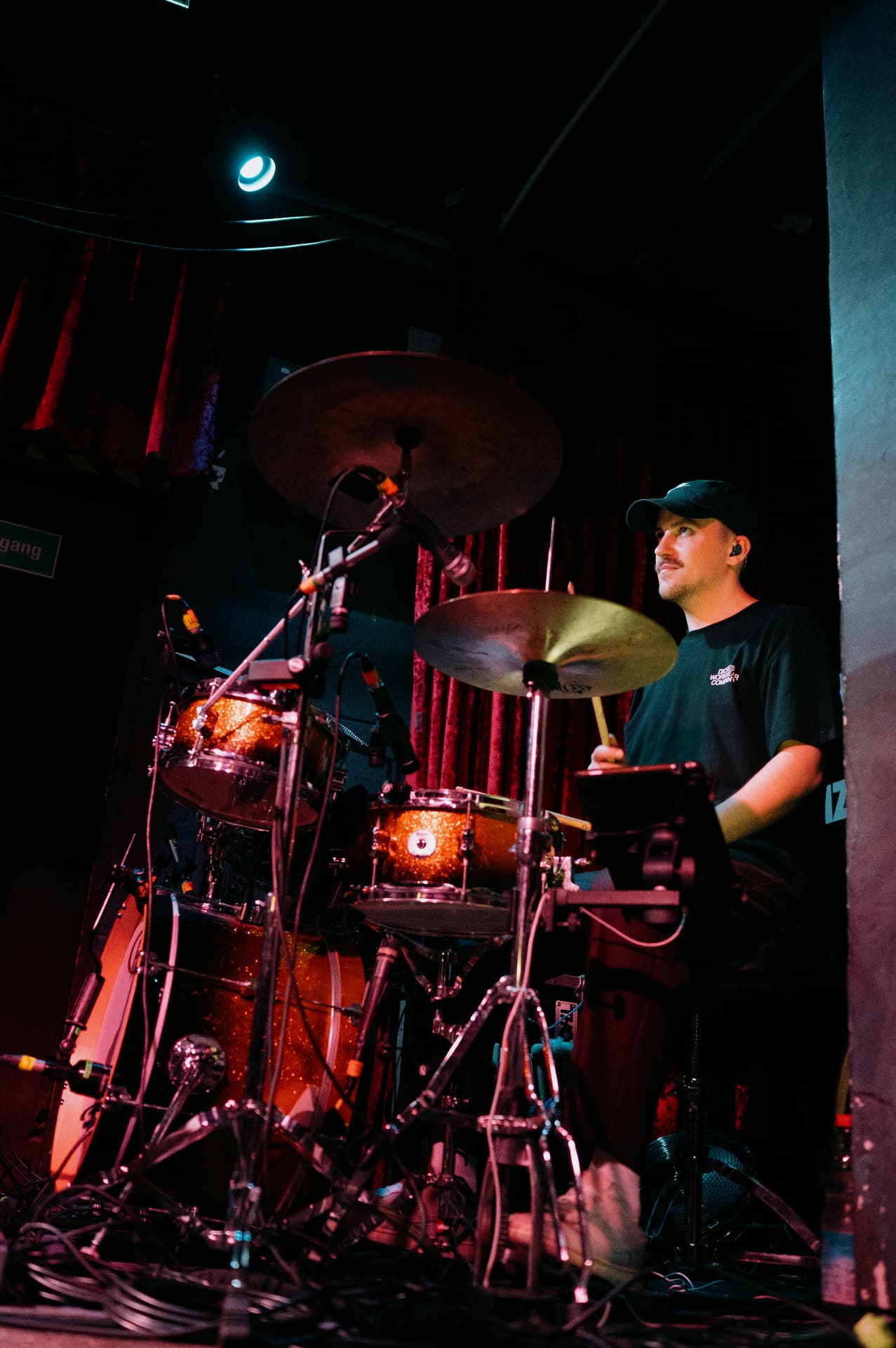 Julian Feuchter at the drums in a club under coloured stage light